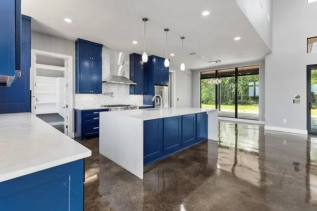 a kitchen with stainless steel appliances granite countertop a sink a oven and a wooden cabinets