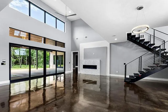 a view of an empty room with window and wooden floor