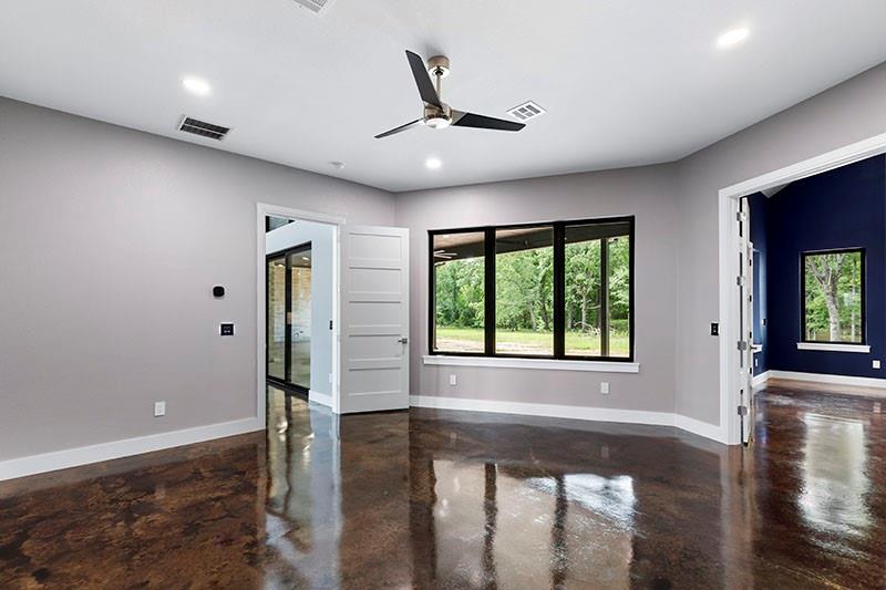 186 Martin Lane Sadler, TX 76264 - Photo 22 of 39 a view of an empty room with window wooden floor and a kitchen view