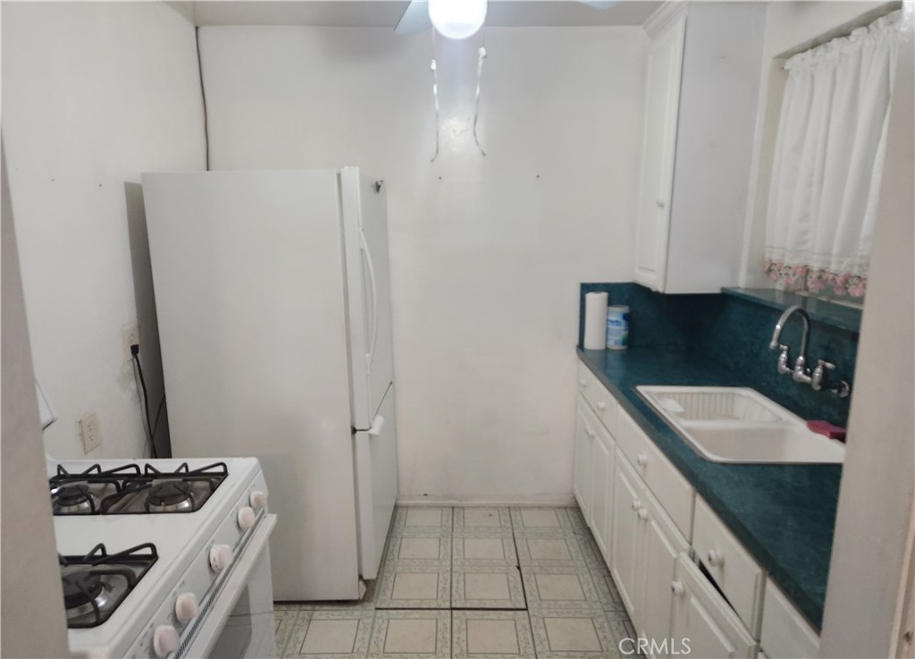 13754 Weidner Street Pacoima, CA 91331 - Photo 11 of 16 a kitchen with a sink stove and refrigerator