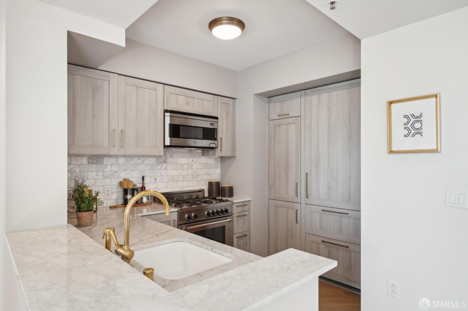 401 Harrison Street, Unit 9H San Francisco, CA 94105 - Photo 11 of 44 a kitchen with stainless steel appliances a refrigerator and a stove top oven