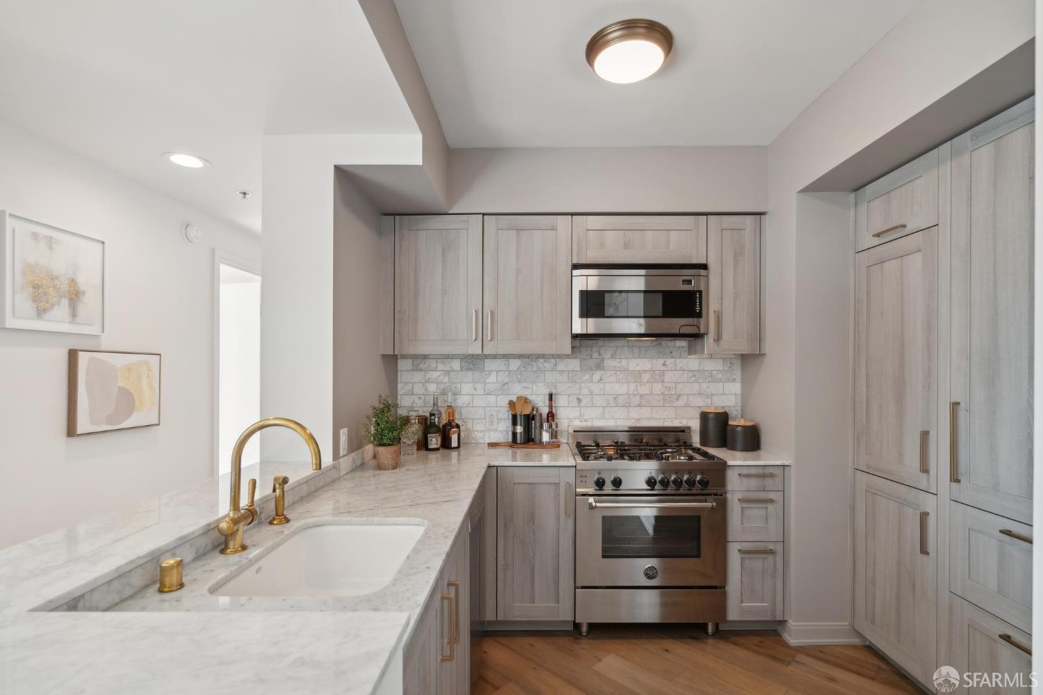 401 Harrison Street, Unit 9H San Francisco, CA 94105 - Photo 12 of 44 a kitchen with stainless steel appliances a stove microwave and sink