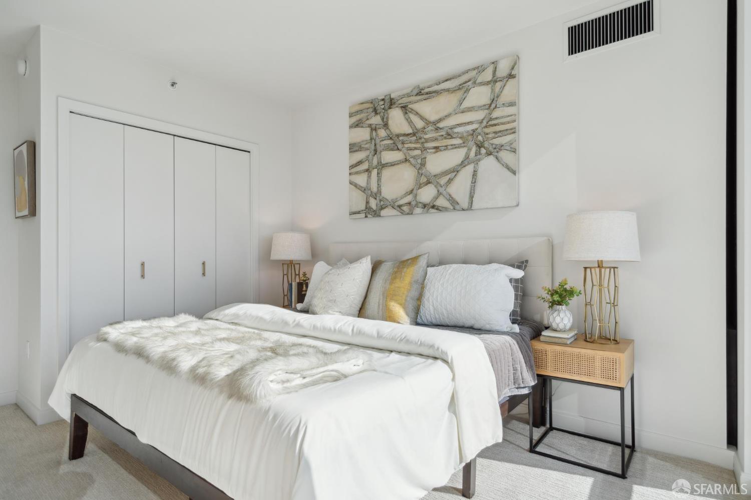 401 Harrison Street, Unit 9H San Francisco, CA 94105 - Photo 17 of 44 a bedroom with a bed and a lamp on dresser