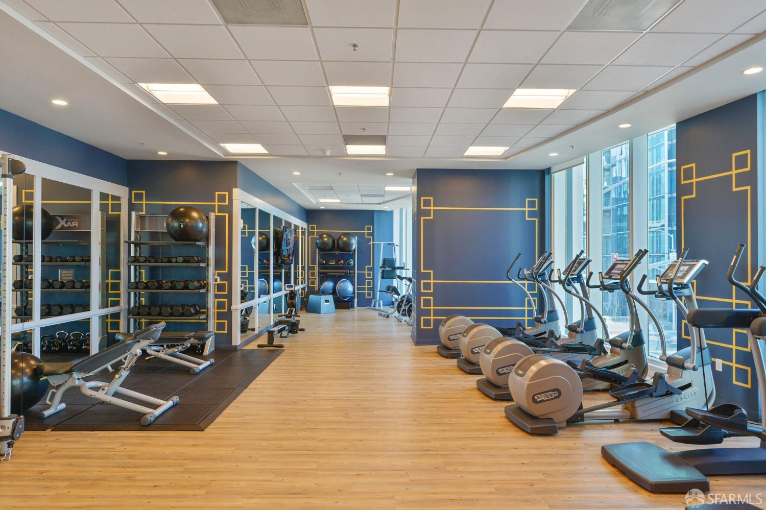 401 Harrison Street, Unit 9H San Francisco, CA 94105 - Photo 30 of 44 a room with gym equipment and large mirror