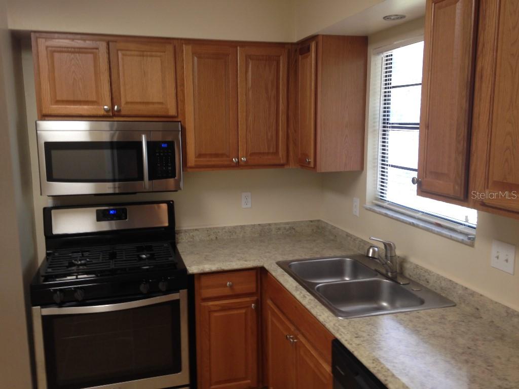 2829 Northwest 40th Place Gainesville, FL 32605 - Photo 5 of 15 a kitchen with granite countertop a sink stainless steel appliances and cabinets