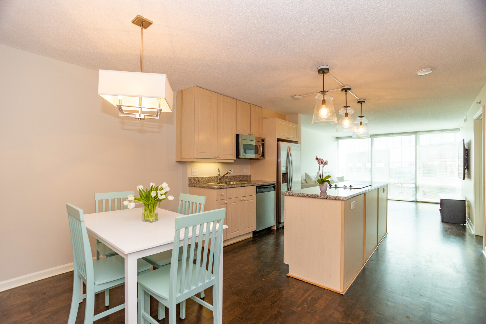 800 Elgin Road, Unit 1115 Evanston, IL 60201 - Photo 5 of 17 a kitchen with a dining table chairs and stainless steel appliances
