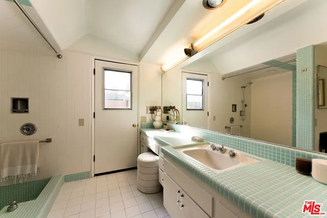 a bathroom with a granite countertop sink and a mirror