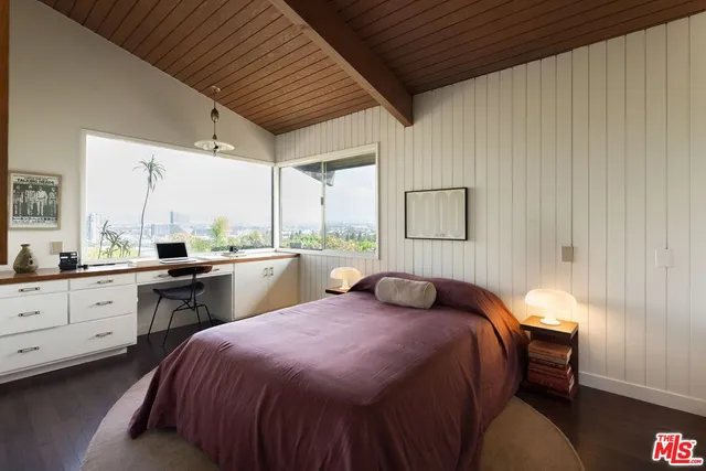 a bedroom with a bed and a desk