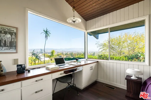 a room with a large window and wooden floor