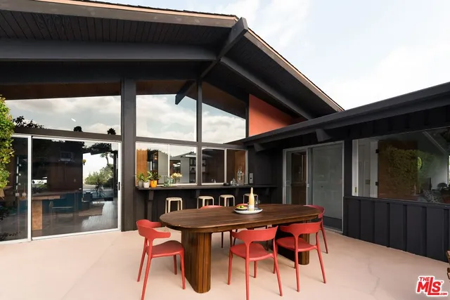 a patio with glass top table and chairs