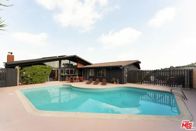 a view of a house with a big yard and sitting area