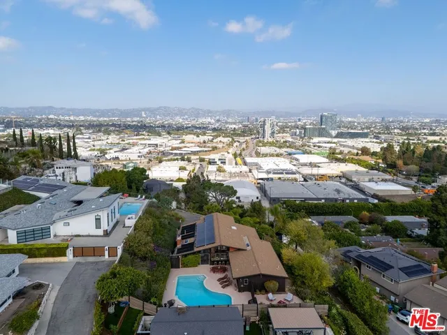 an aerial view of a city with lots of residential buildings and ocean view in back