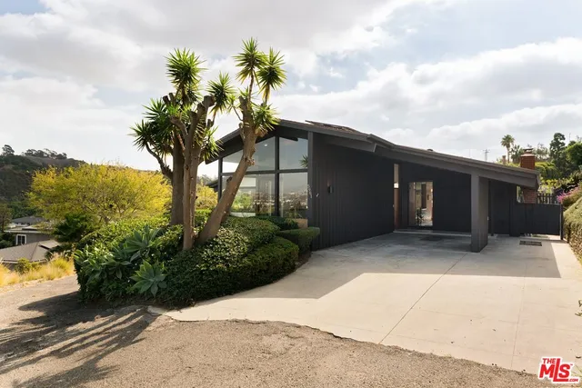 a view of a house with a yard and potted plants
