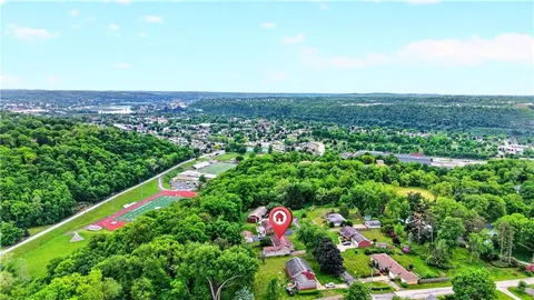 an aerial view of residential houses with outdoor space and trees