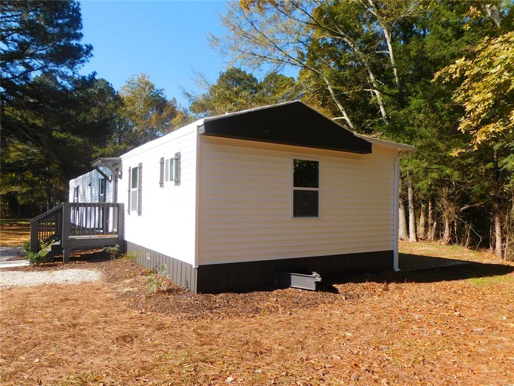 1101 Boswell Road Union Point, GA 30669 - Photo 2 of 60 a front view of a house with a yard covered in snow