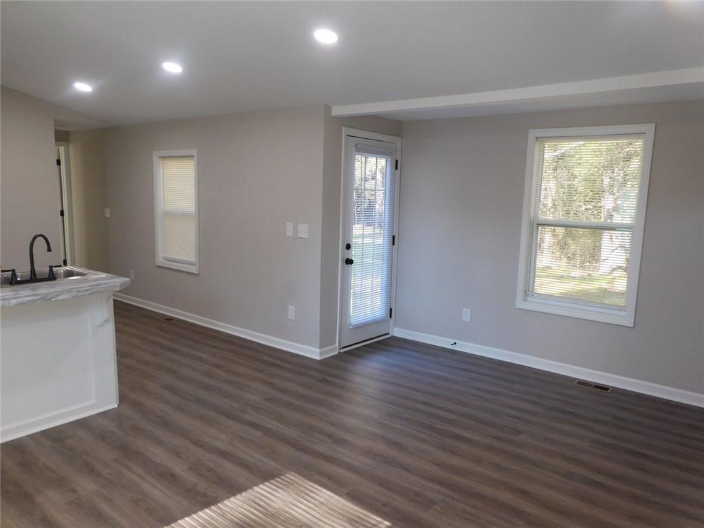 1101 Boswell Road Union Point, GA 30669 - Photo 28 of 60 an empty room with wooden floor and windows