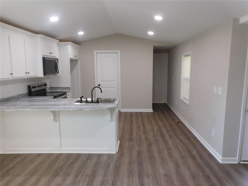 1101 Boswell Road Union Point, GA 30669 - Photo 31 of 60 a view of kitchen with stainless steel appliances granite countertop a stove a sink and a refrigerator with wooden floors