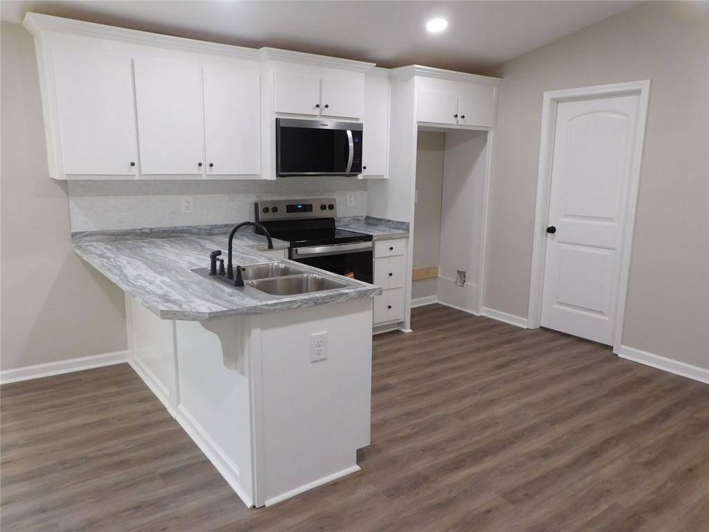 1101 Boswell Road Union Point, GA 30669 - Photo 32 of 60 a kitchen with stainless steel appliances granite countertop a sink stove and microwave