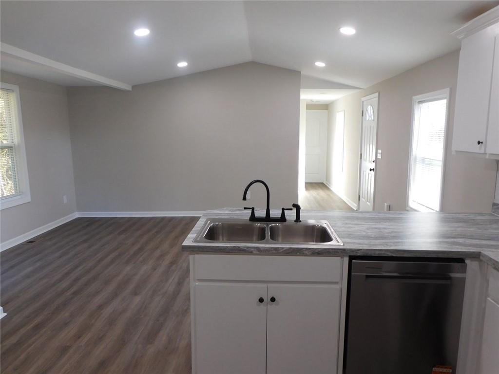 1101 Boswell Road Union Point, GA 30669 - Photo 36 of 60 a kitchen with kitchen island a sink wooden floor and white cabinets