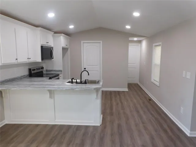 a view of an empty room with wooden floor