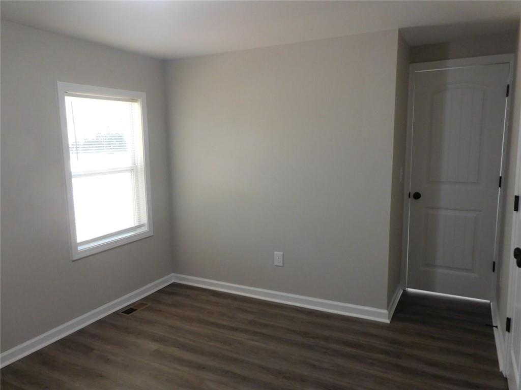 1101 Boswell Road Union Point, GA 30669 - Photo 47 of 60 an empty room with wooden floor and windows