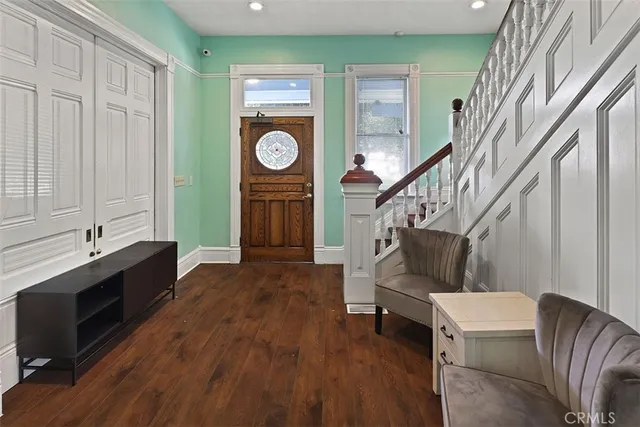 a living room with couches and a stove with wooden floor