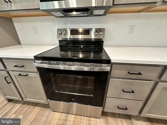 a stove top oven sitting inside of a kitchen