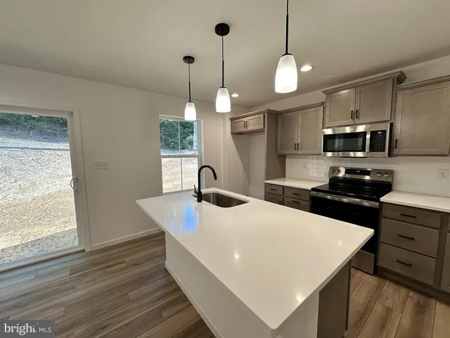 a kitchen with kitchen island a wooden floor and white appliances