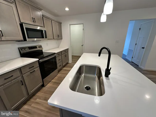 a kitchen with sink a microwave a stove and refrigerator