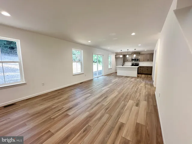 a view of a living room hardwood floor and a kitchen