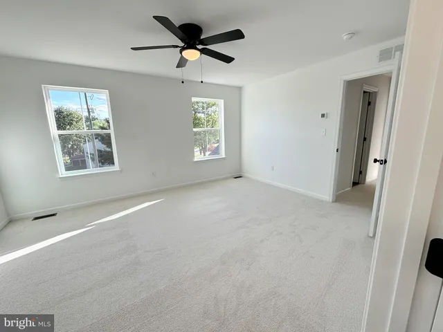 a view of a big room with windows and chandelier fan