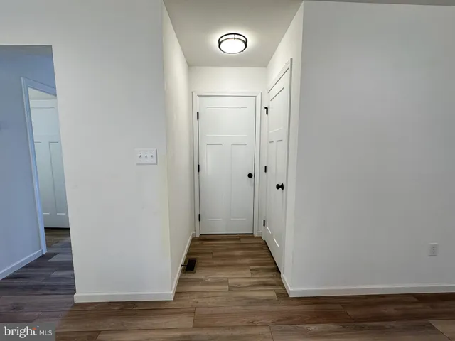 a view of a hallway with wooden floor and front door