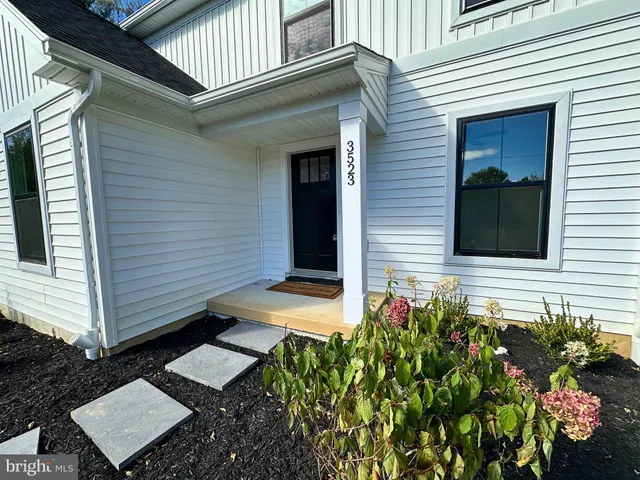 a view of a pathway of the house with a yard