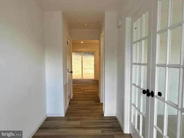 a view of a hallway with wooden floor and staircase