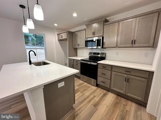 a kitchen with stainless steel appliances sink microwave and cabinets