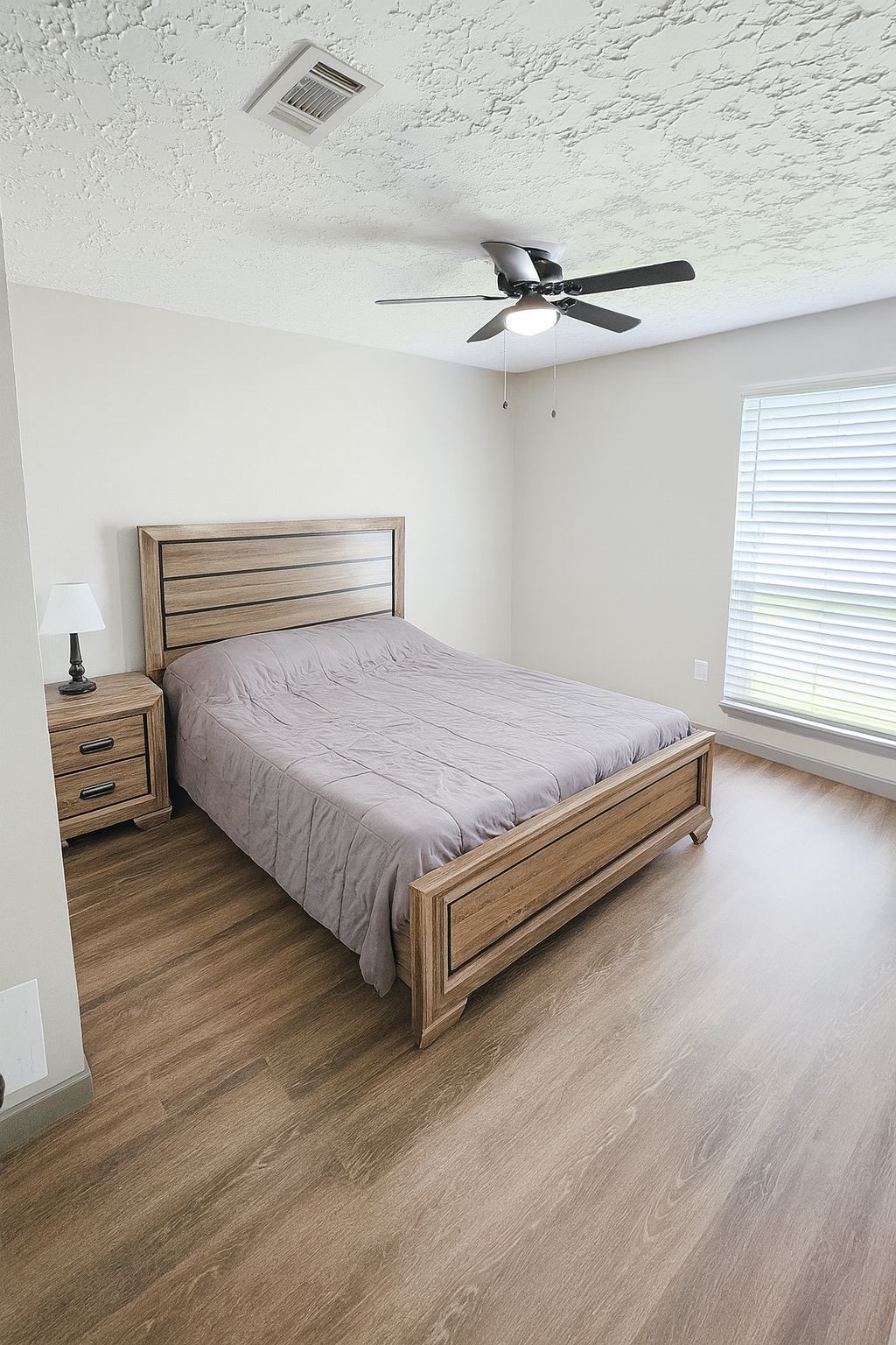9735 Stonemont Road La Porte, TX 77571 - Photo 7 of 11 a spacious bedroom with a bed and a ceiling fan