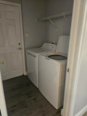 a utility room with wooden floor washer and dryer