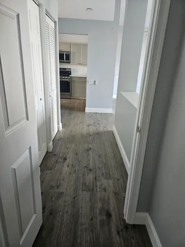 a view of a hallway view with furniture and wooden floor