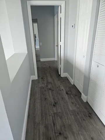 a view of a hallway with wooden floor and staircase
