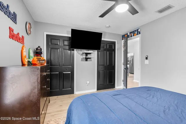 a bedroom with a large bed and a chandelier