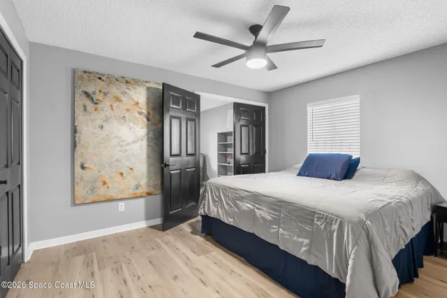 a bedroom with a large bed and a chandelier