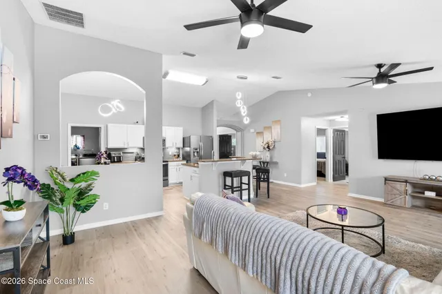 a living room with a couch a dining table and a flat screen tv