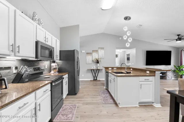 a kitchen with stainless steel appliances granite countertop a sink and cabinets