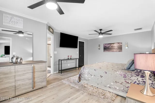 a bedroom with a large bed and a chandelier