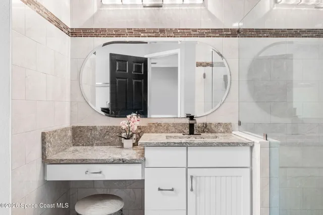 a bathroom with a granite countertop sink toilet and shower