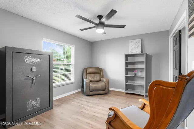 a view of a livingroom with wooden floor and a refrigerator