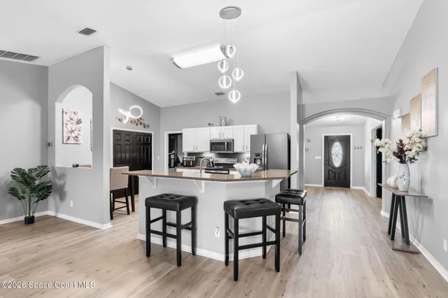 a bedroom with a bed and a flat tv screen on dresser