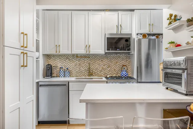 a kitchen with stainless steel appliances a refrigerator and a stove top oven