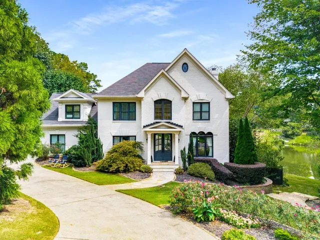a front view of a house with a yard and potted plants