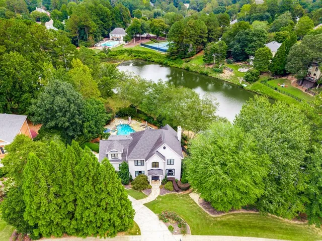 an aerial view of residential houses with outdoor space and trees